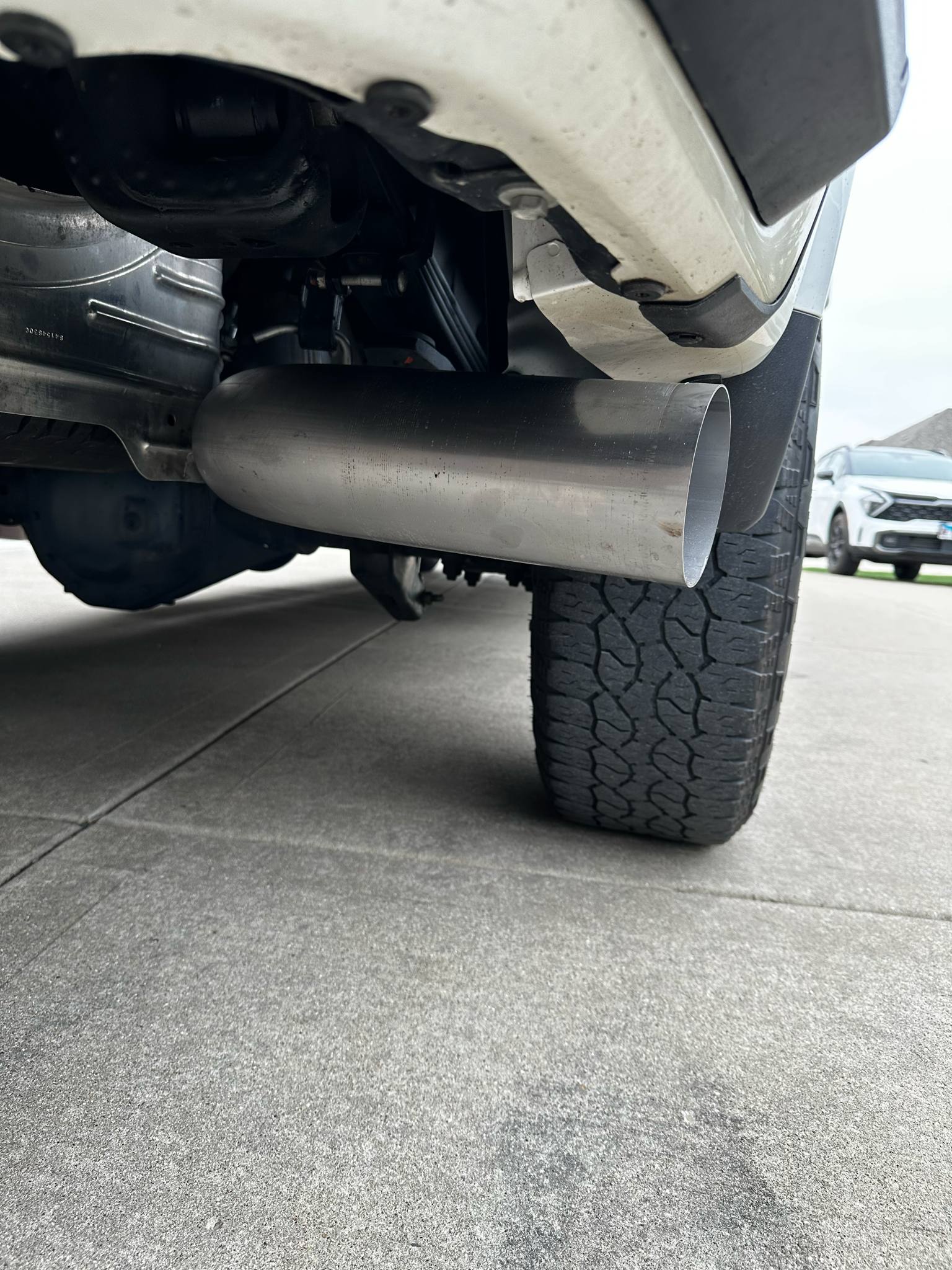Duramax 2001-2027 stainless steel 5-inch exhaust tailpipe section by DP Customs, showing the polished metal and pipe connection.