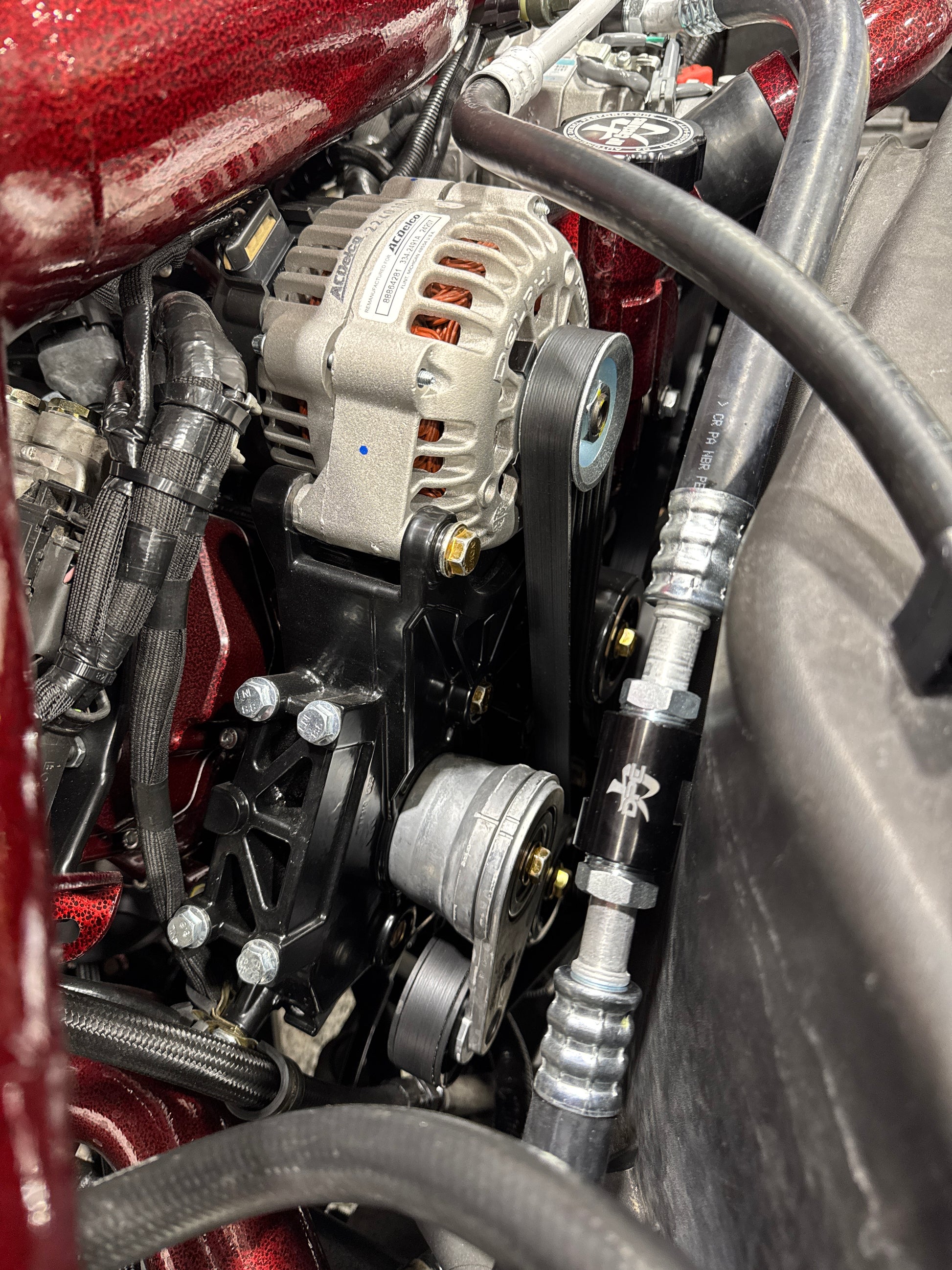 DP Customs 03-07 Duramax front route AC suction line, showing metal tubing and fittings for vehicle cooling system.