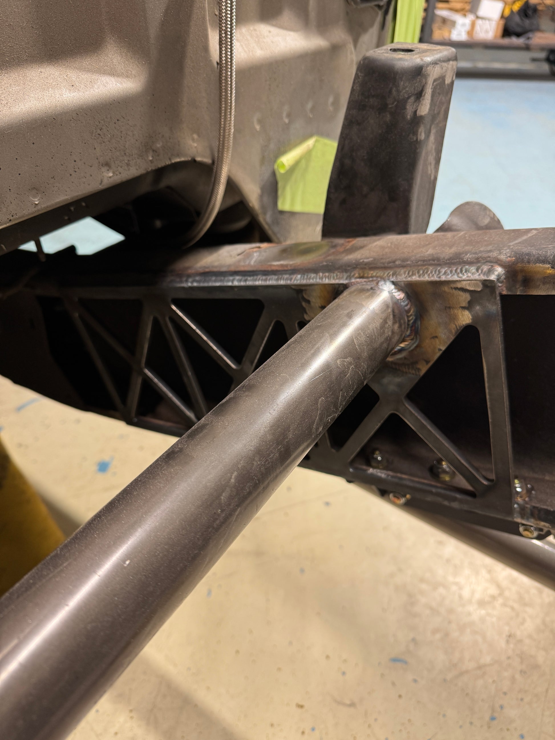DP Customs 1999-2010 GM HD frame support brace showing the black metal bracket and mounting points for vehicle stabilization.