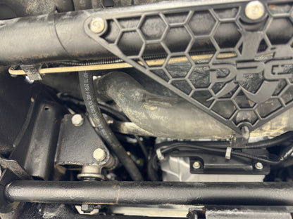 DP Customs radiator hose support bracket for 2001-2010 Duramax engines, mounted on engine bay with hoses attached.