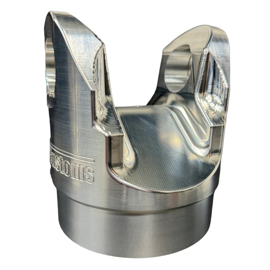 DP Customs billet aluminum 1480 driveshaft yoke, shown in close-up with polished finish and precise machining details.