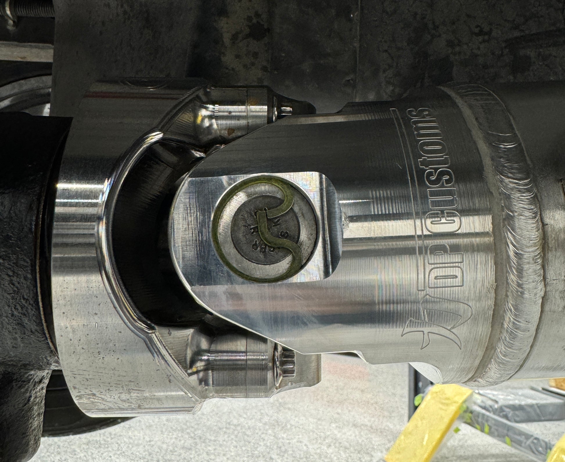 DP Customs billet aluminum driveshaft yoke for 1480 U-joint, showing polished metal with precise machining details.