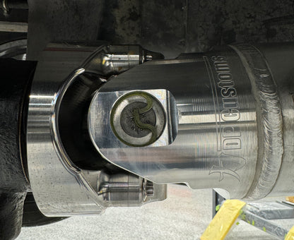 DP Customs billet aluminum driveshaft yoke for 1480 U-joint, showing polished metal with precise machining details.