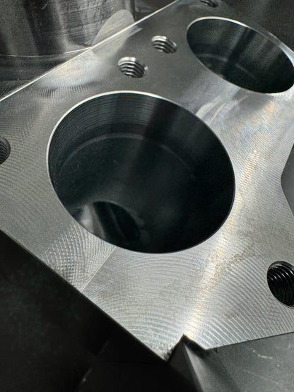 DP Customs Duramax billet T6 wastegate pedestal mounted on engine, showcasing precision-machined metal components.