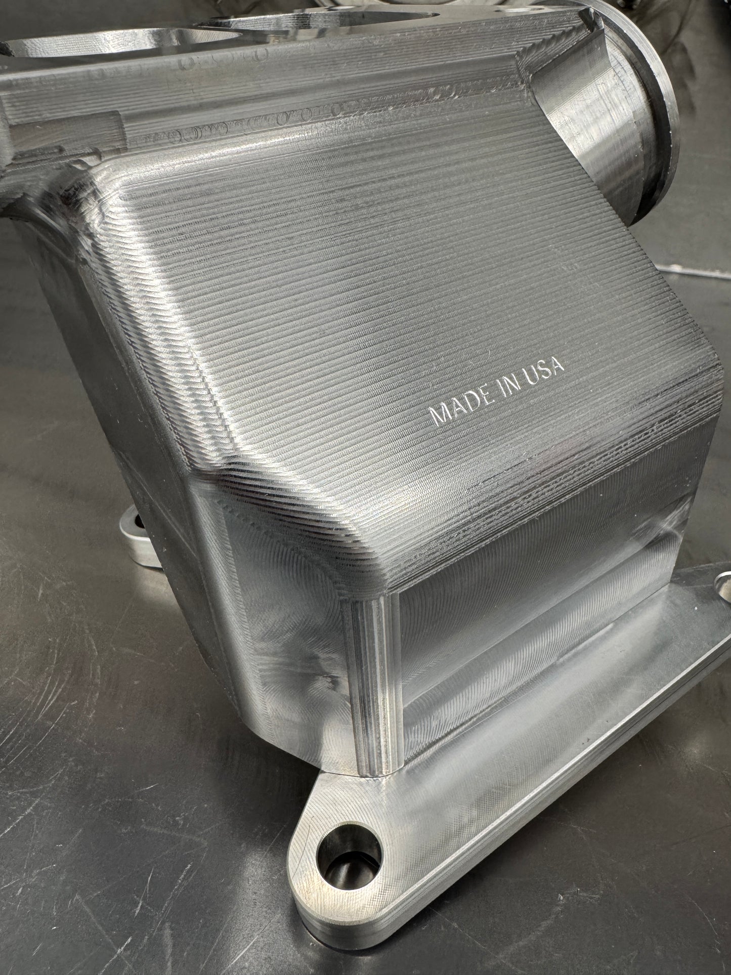 DP Customs Duramax billet T6 wastegate pedestal mounted on engine, showcasing durable metal construction and precision machining.