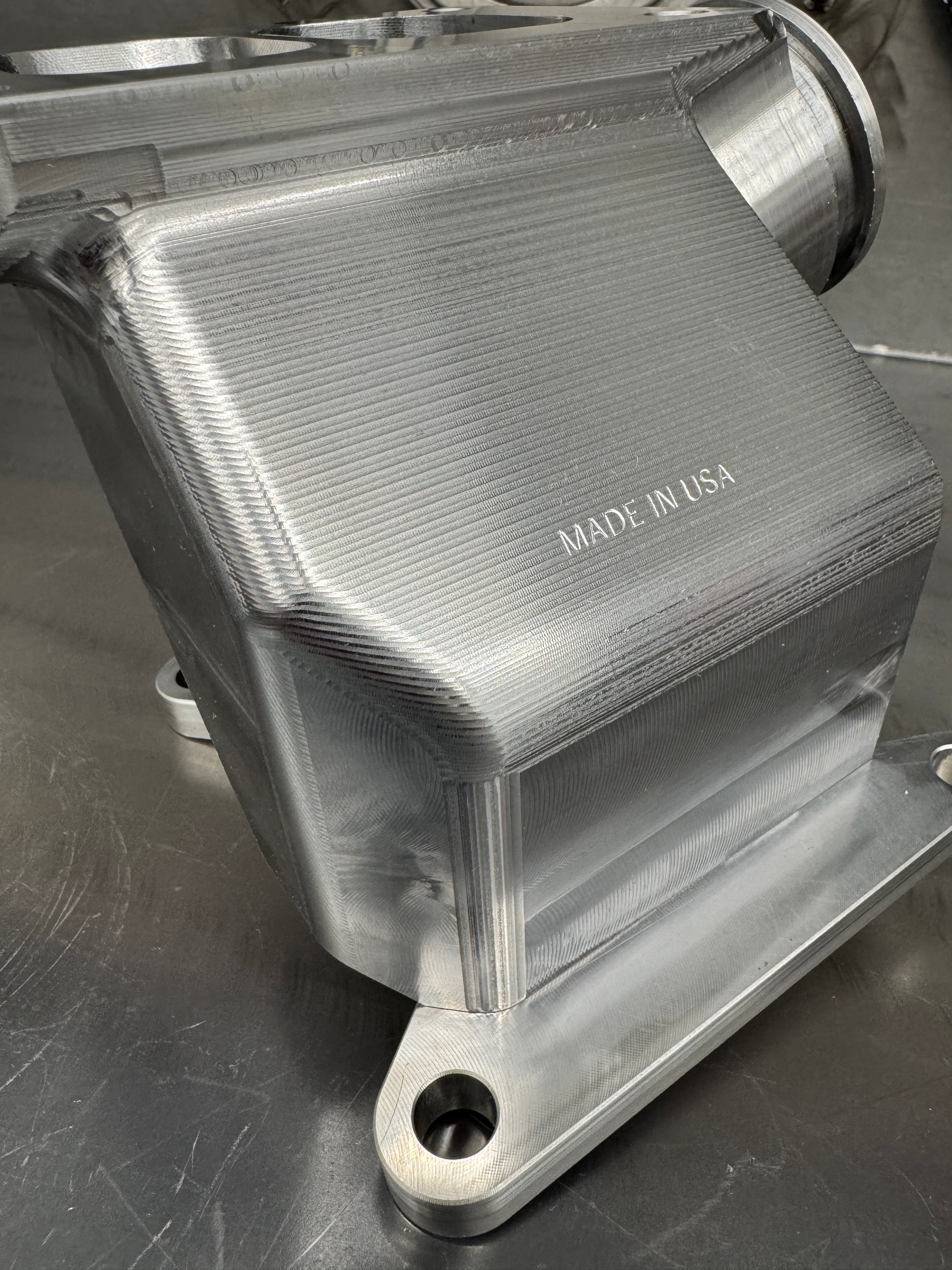 DP Customs Duramax billet T6 wastegate pedestal mounted on engine, showcasing durable metal construction and precision machining.