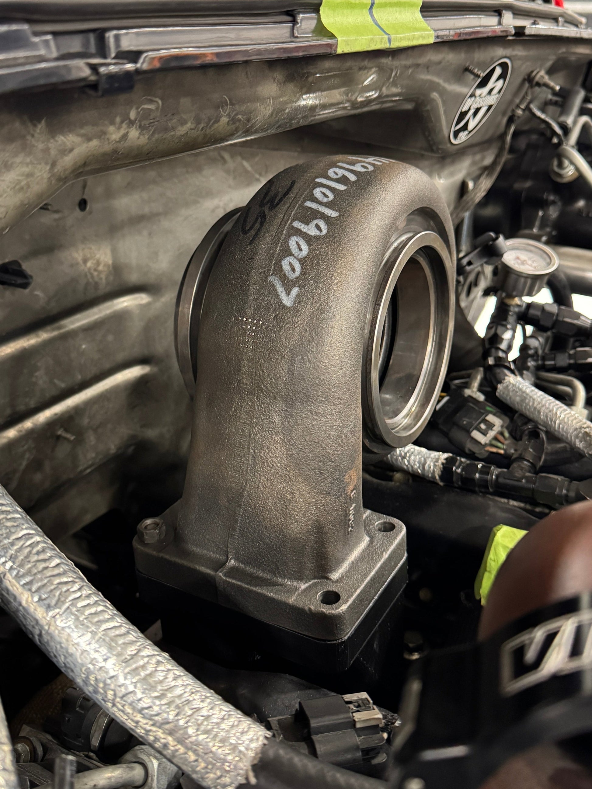 DP Customs Duramax billet T6 wastegate pedestal mounted on engine component with detailed machining and sturdy construction.