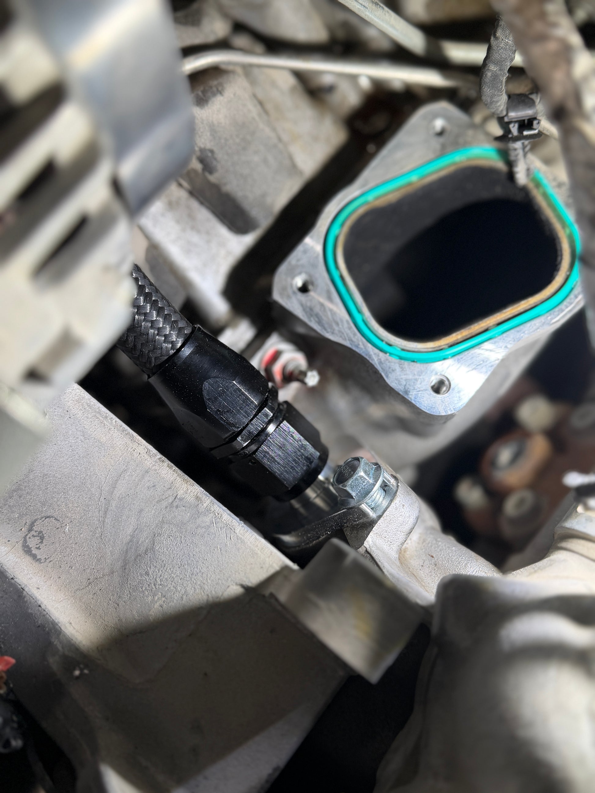DP Customs L5P Duramax billet side thermostat adapter fitting with -10 AN connection, shown in a close-up view.