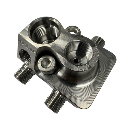 DP Customs LB7 Fuel Distribution Block showing metal construction and multiple connection ports for diesel engine fuel lines.