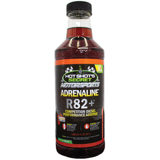 DP Customs Hot Shot’s Secret Adrenaline R82+ Diesel Race Additive bottle on a workshop table, showing the product label and branding.