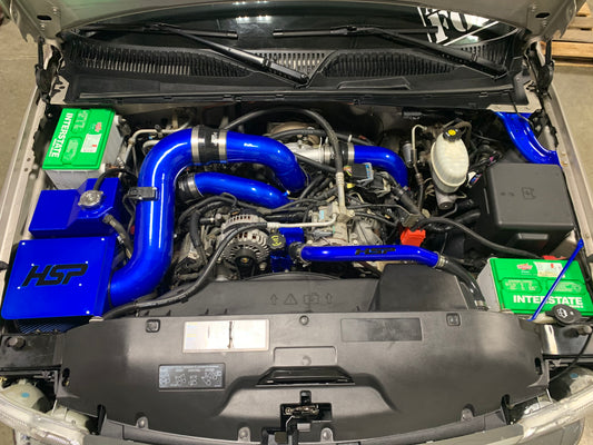 DP Customs HSP LLY Duramax intercooler pipe kit with polished metal pipes and connectors, installed in a diesel truck engine bay