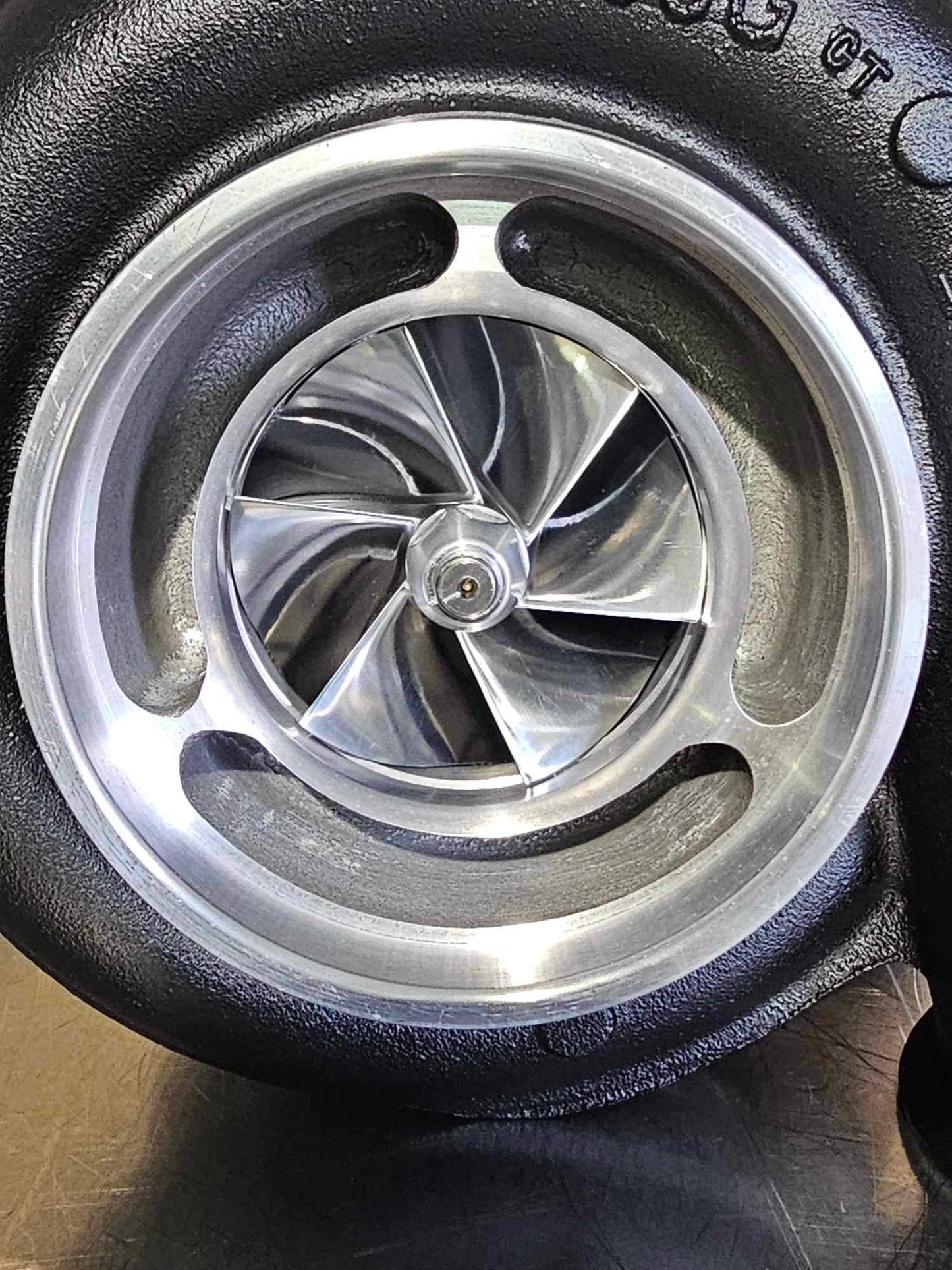 Close-up of the DP Customs JZM S476 motorcycle part with detailed metal finish and branding visible.