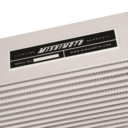 Mishimoto intercooler for 2001-2005 Duramax diesel trucks, black aluminum core with mounting brackets, displayed on a vehicle.