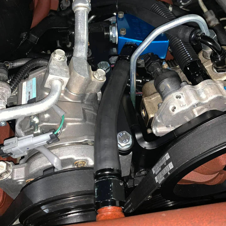 SoCal Diesel water pump bypass installed in a vehicle engine, showing the bypass hose and connection points.