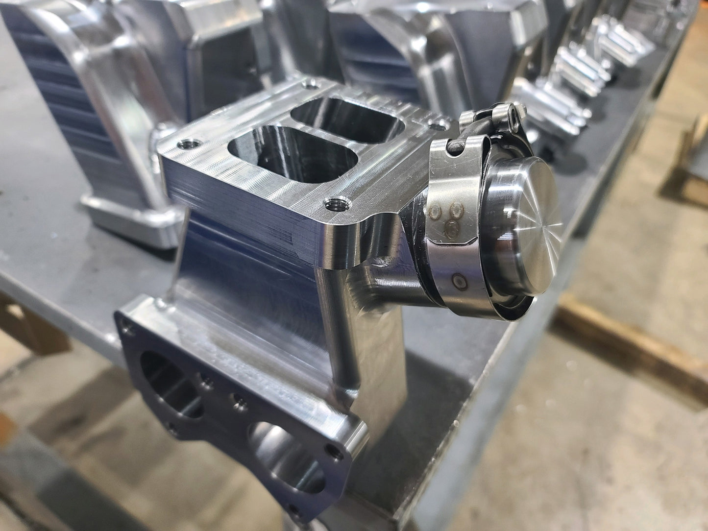 DP Customs Duramax billet T4 wastegate pedestal showing polished metal construction and mounting features for turbocharger setup.