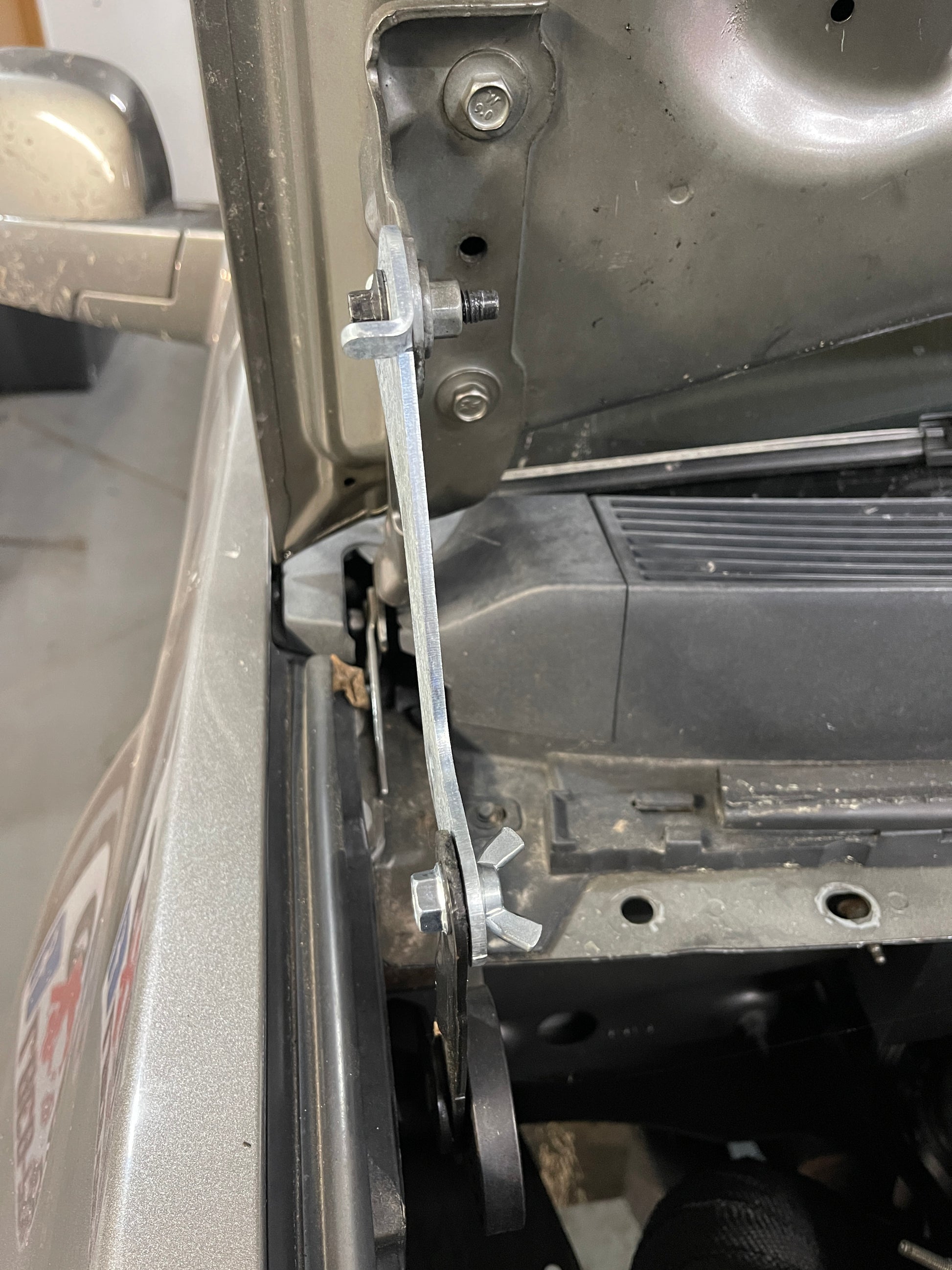 DP Customs High Access Hood Brackets for 2007.5-2016 GM trucks, showing sturdy metal brackets installed on vehicle hood.