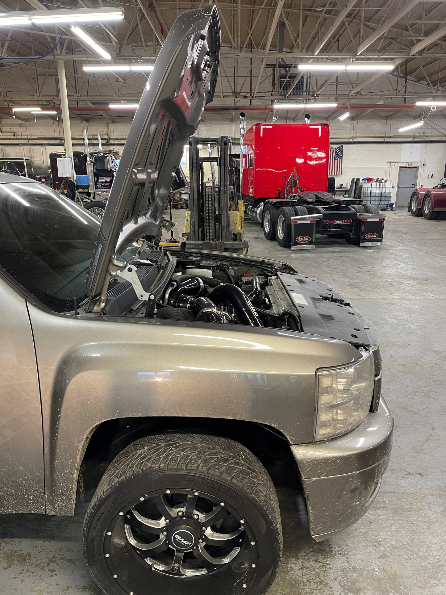 DP Customs High Access Hood Brackets installed on a 2007.5-2016 GM truck, showing sturdy metal brackets for easy hood access.