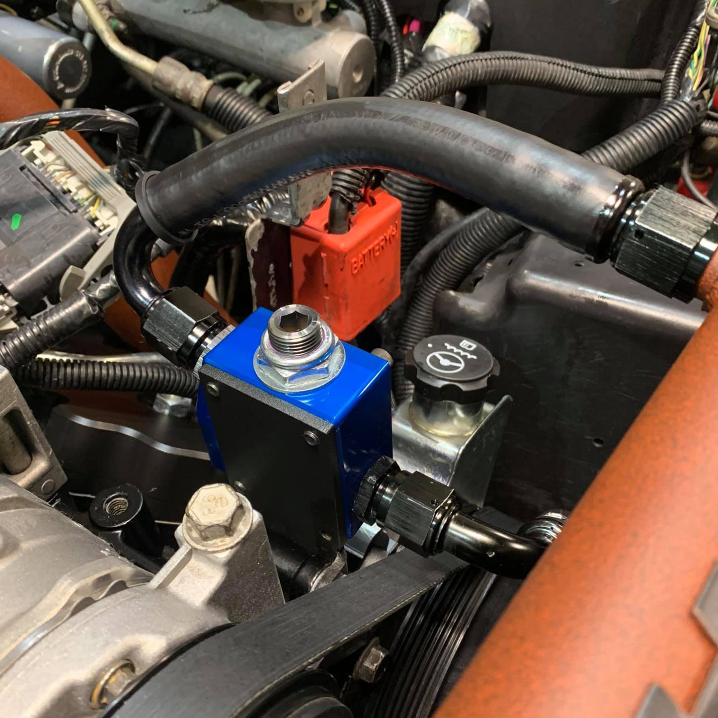 DP Customs SoCal Diesel waterpump bypass bracket installed on a vehicle engine, showcasing durable metal construction and precise fit.